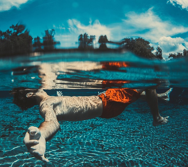 A diver floating calmly underwater in clear blue water.